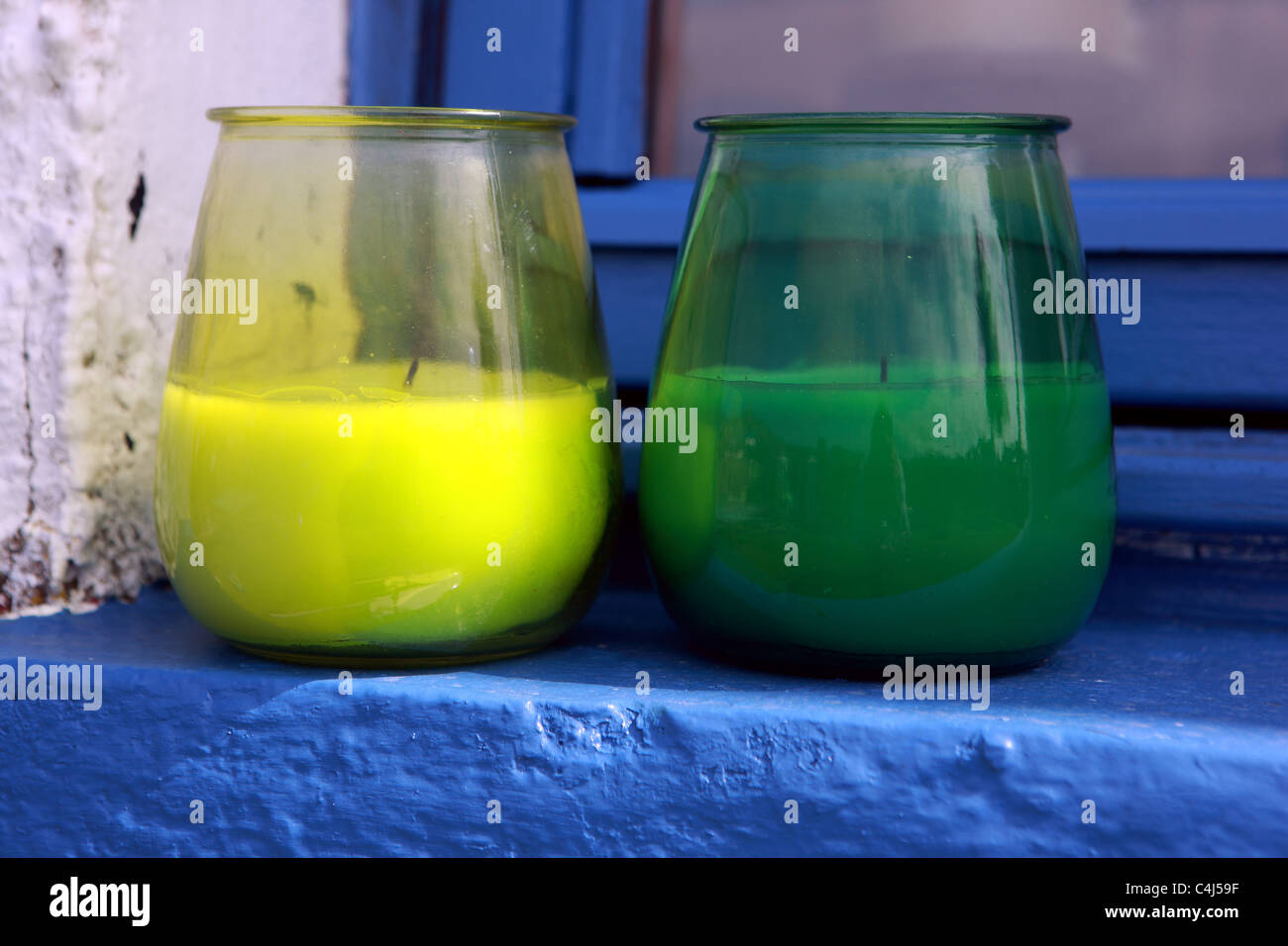 Insect repellent brightly coloured candles on blue window ledge Stock ...