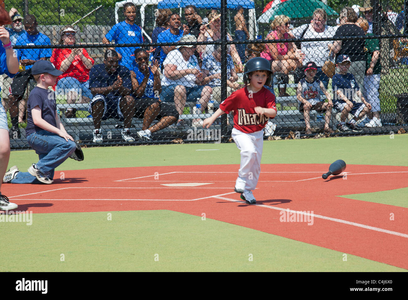 Children with disabilities play baseball in the Miracle League. Stock Photo