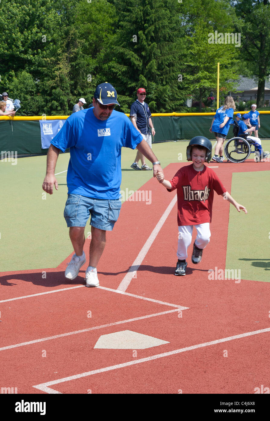 Children with disabilities play baseball in the Miracle League. Stock Photo