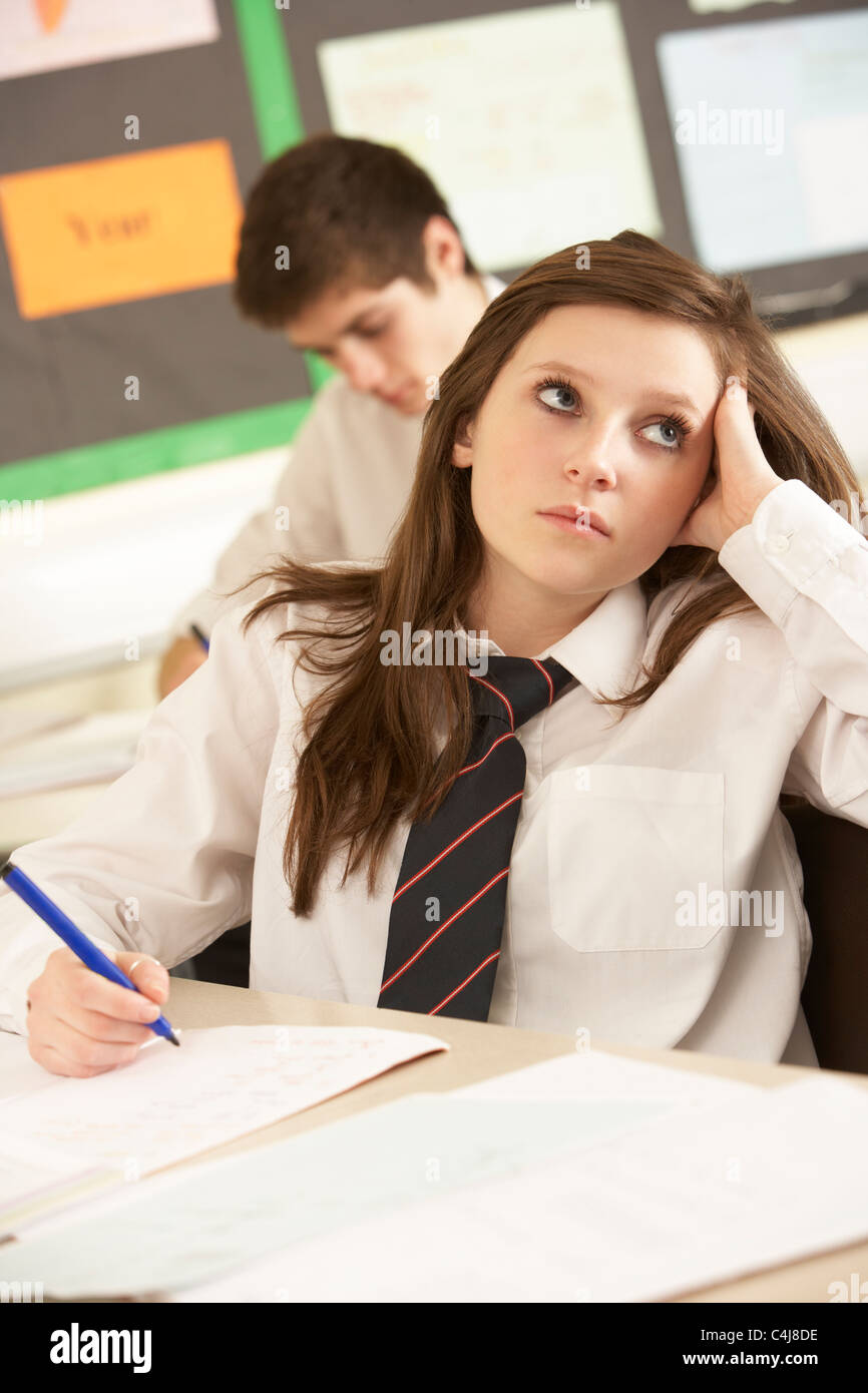 Bored Female Teenage Student Studying In Classroom Stock Photo