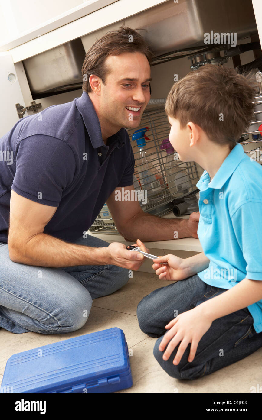 Son Helping Father To Mend Sink In Kitchen Stock Photo - Alamy