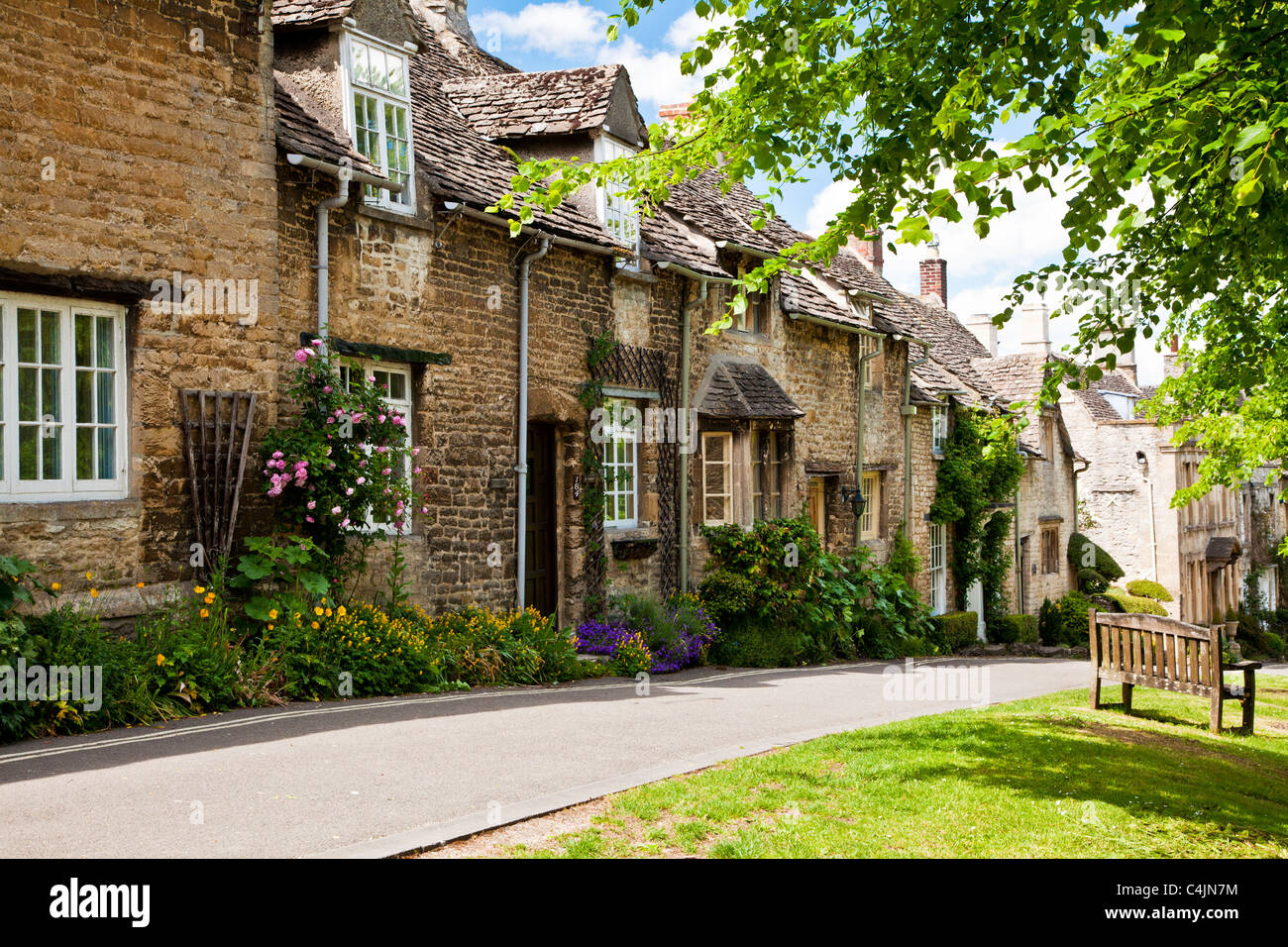Row of pretty Cotswold stone cottages in the tourist town of Burford, Oxfordshire, England, UK
