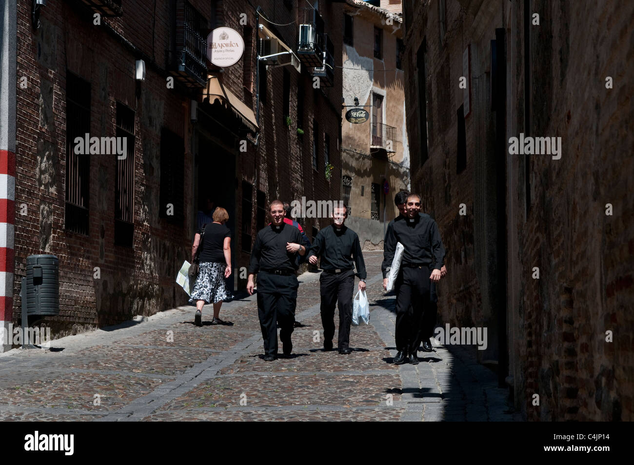 Young priests walking down cobbled street, Toledo, Spain Stock Photo