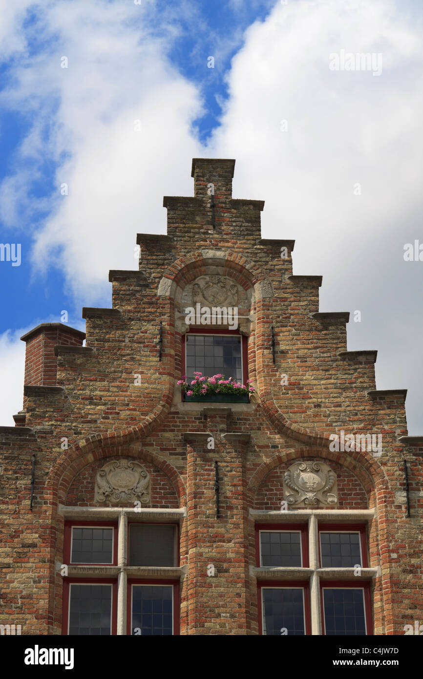 Stepped gable and window details of one of the brick houses in Jan Van Eyck Square, Bruges, Belgium Stock Photo
