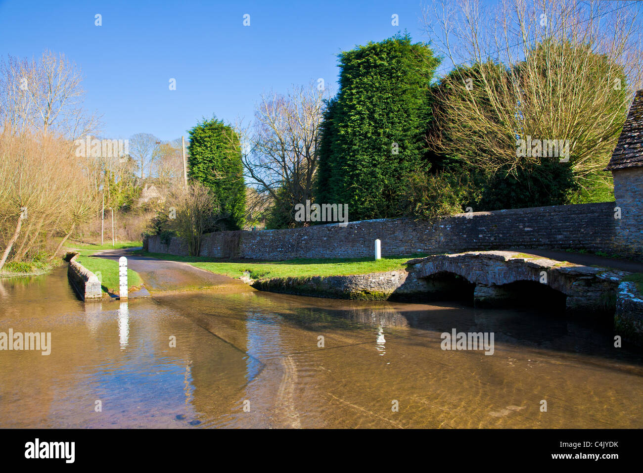 The ford in the pretty Cotswold village of Shilton, Oxfordshire, England, UK on a sunny day in early spring Stock Photo