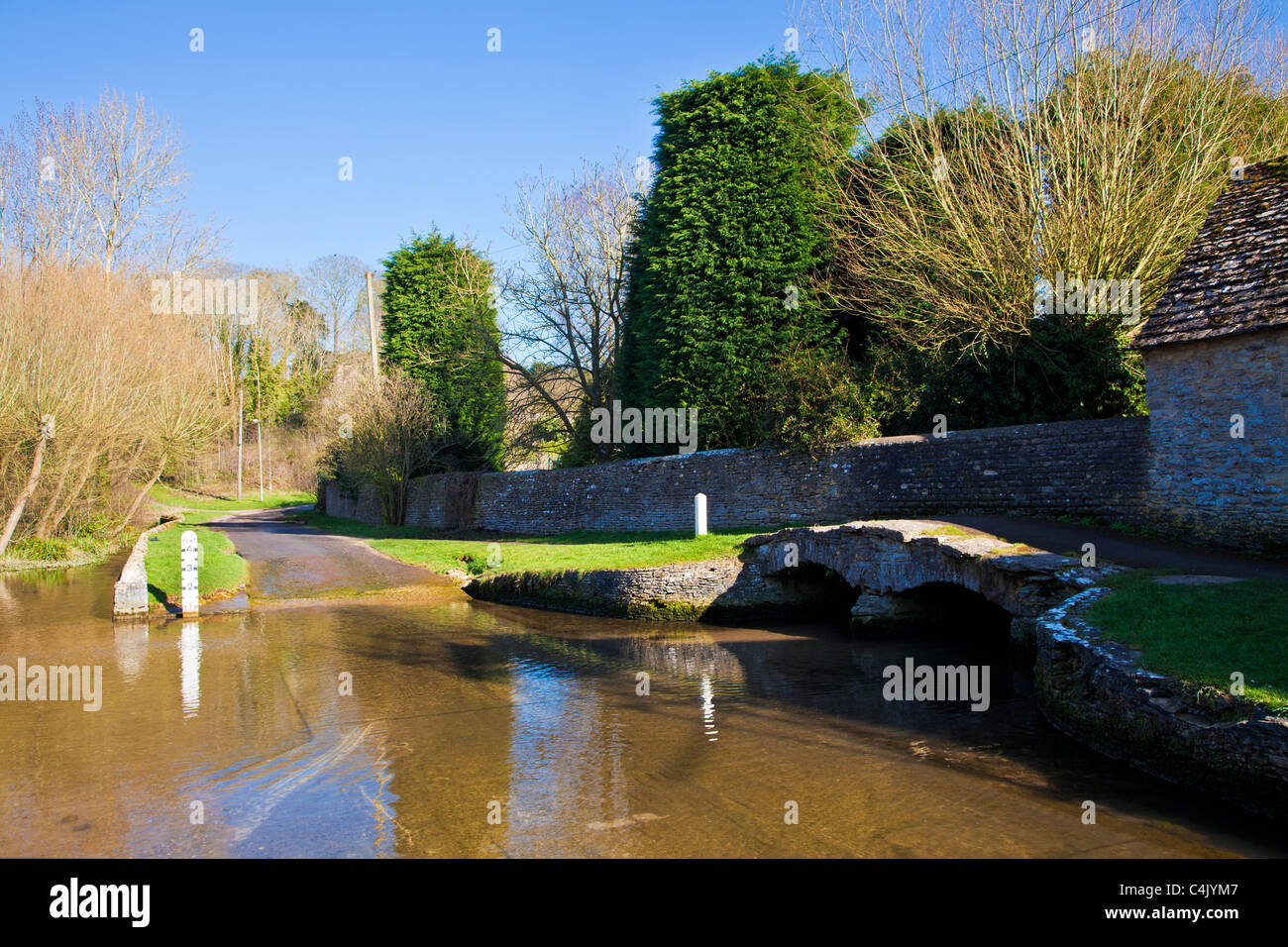 The ford in the pretty Cotswold village of Shilton, Oxfordshire, England, UK on a sunny day in early spring Stock Photo