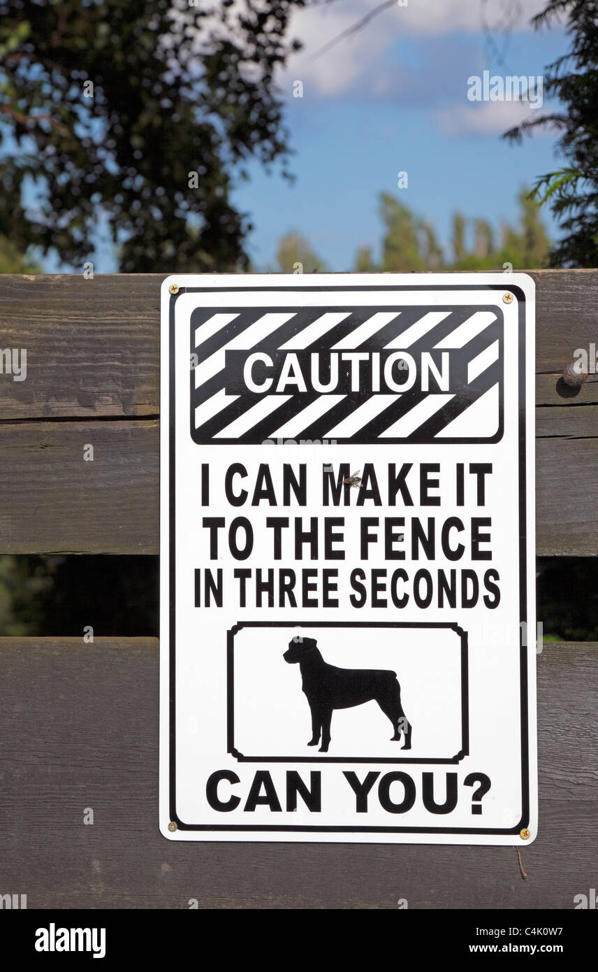 Dog warning sign on gate to private property - I can make it to the fence in three seconds, can you? Stock Photo