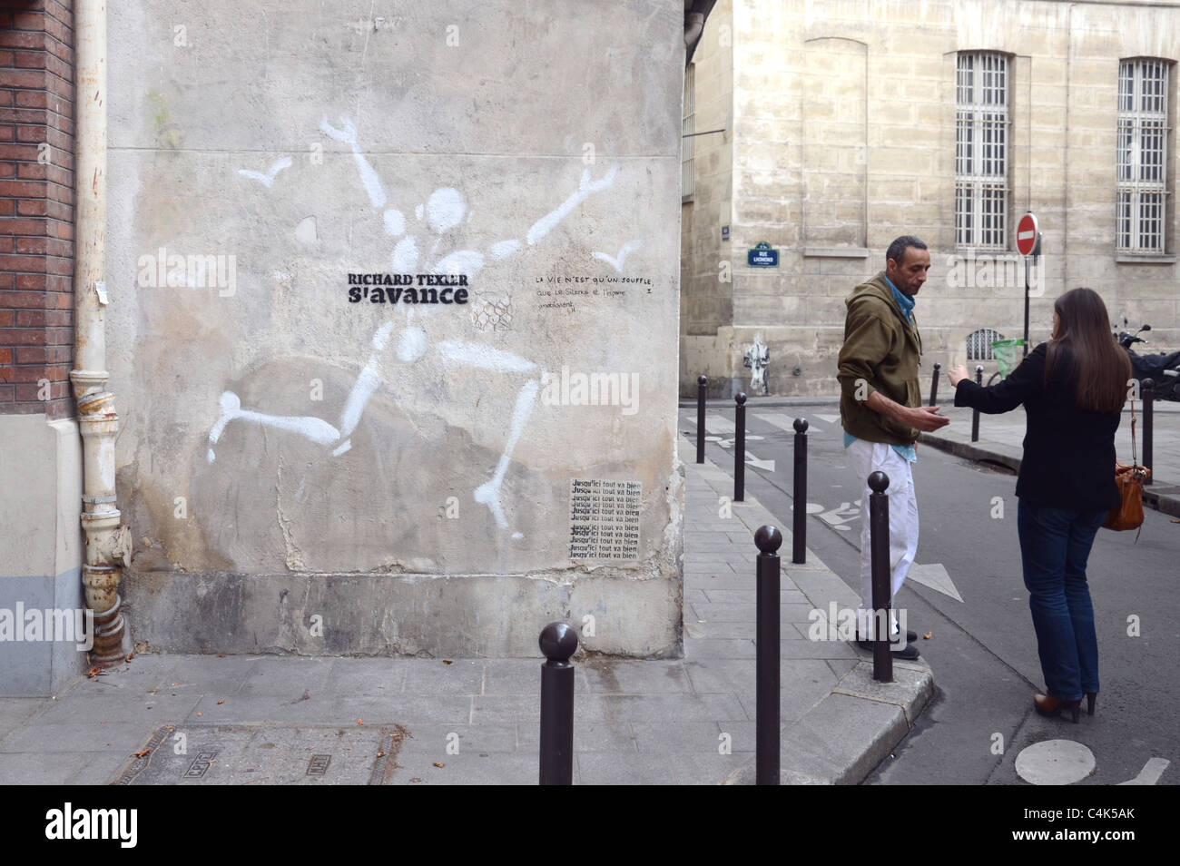 A piece of graffiti by Jérome Mesnager in the Rue du Pot de Fer, Paris  France. Next to it a couple converse Stock Photo - Alamy