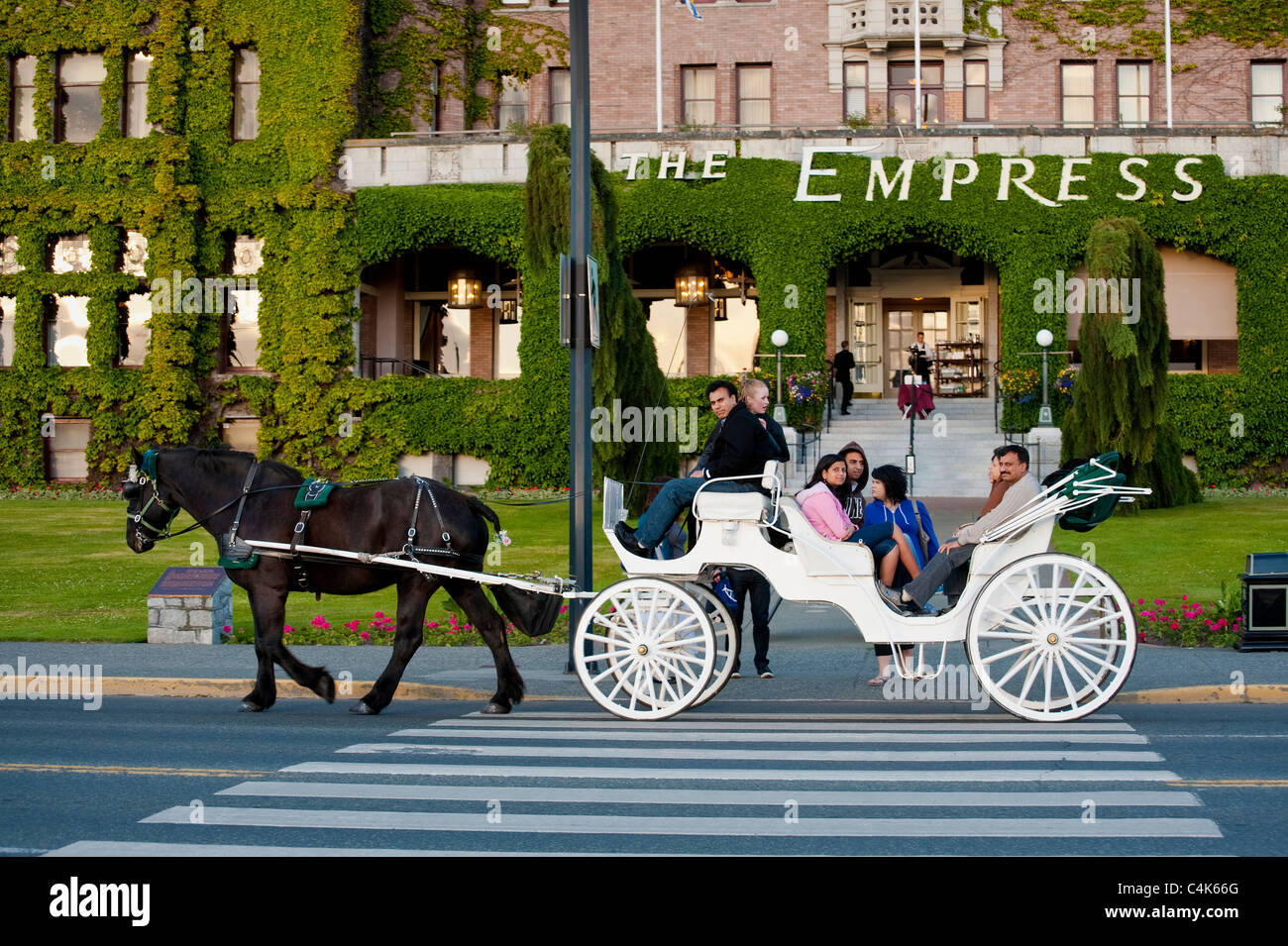 A classic horse and carriage delivers passengers to the Fairmont Empress Hotel in Victoria, British Columbia, Canada. Stock Photo