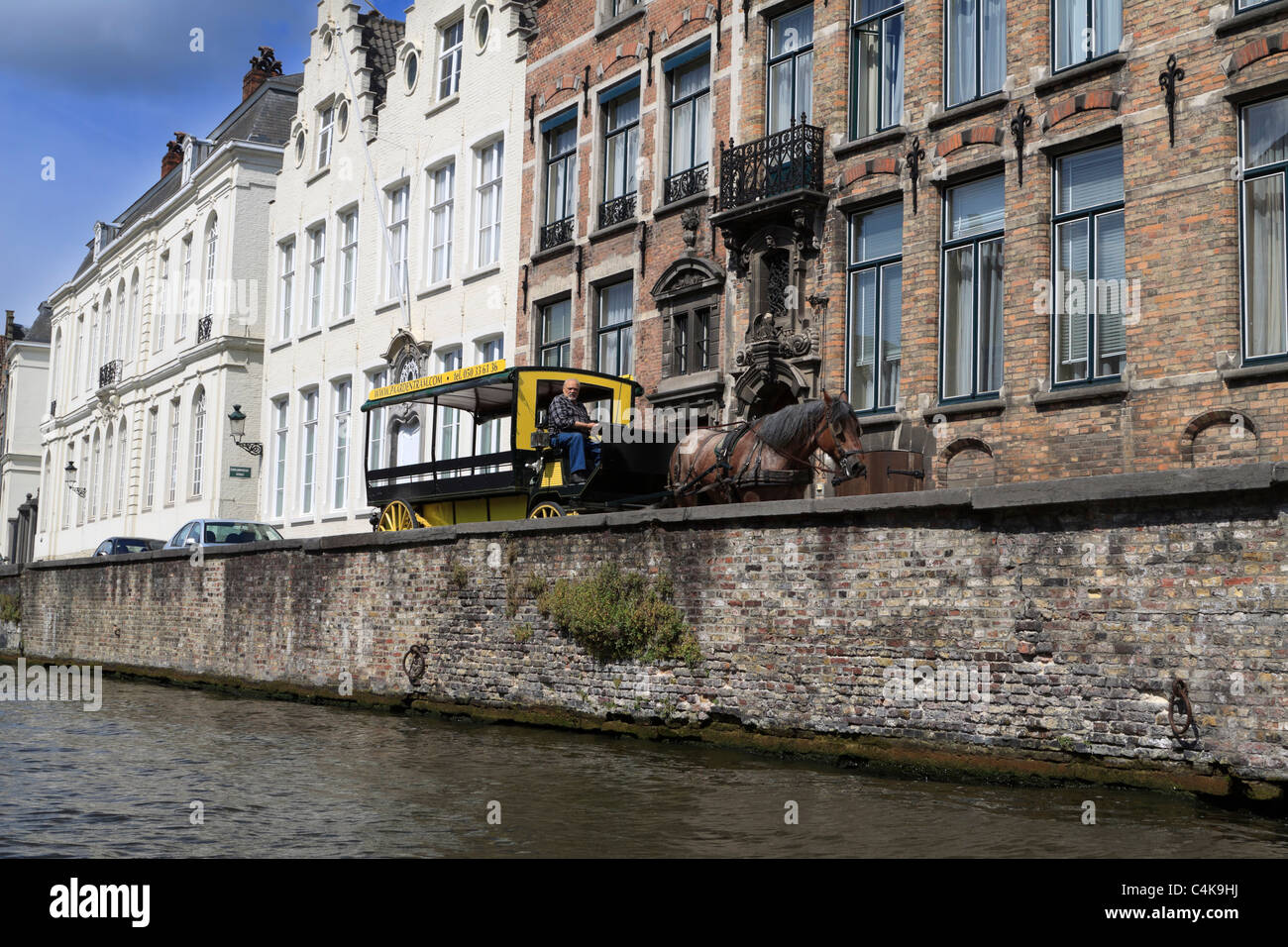 Spieglerei canal, Bruges, Belgium. A horse drawn tram passes the canalside houses. Stock Photo