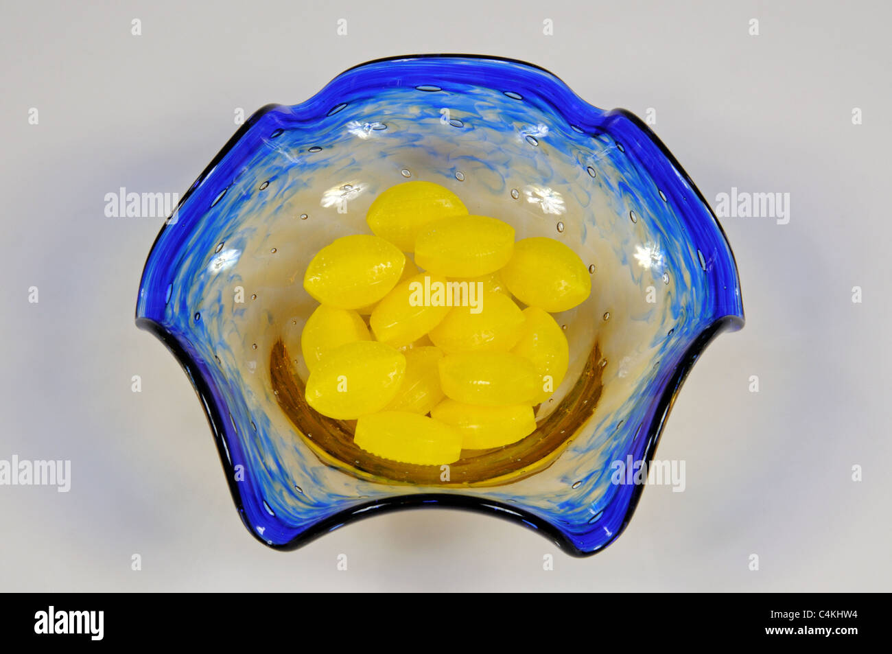 Blue and yellow Gibraltar Glass Dish with Sherbet Lemons, Urb. Calypso, Costa del Sol, Malaga Province, Andalucia, Spain. Stock Photo