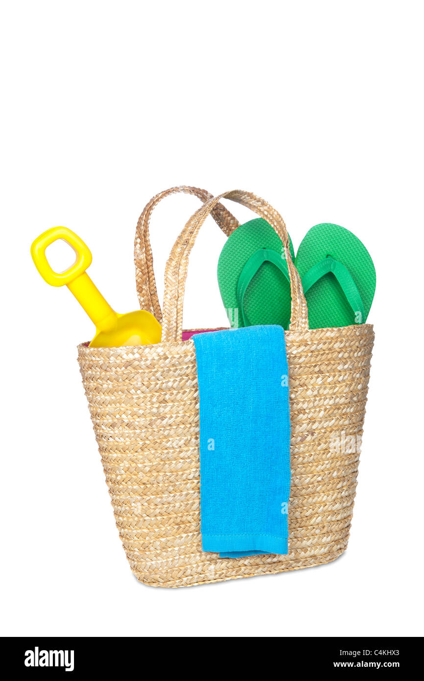 A beach bag carrying a toy shovel, flip flops and a beach towel. Stock Photo