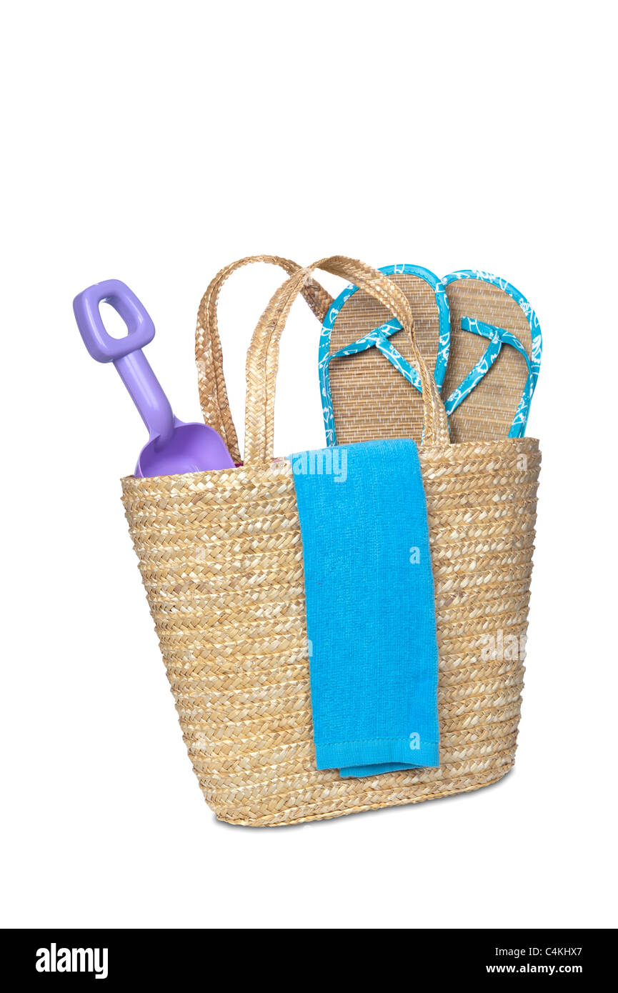 A beach bag carrying a toy shovel, flip flops and a beach towel. Stock Photo