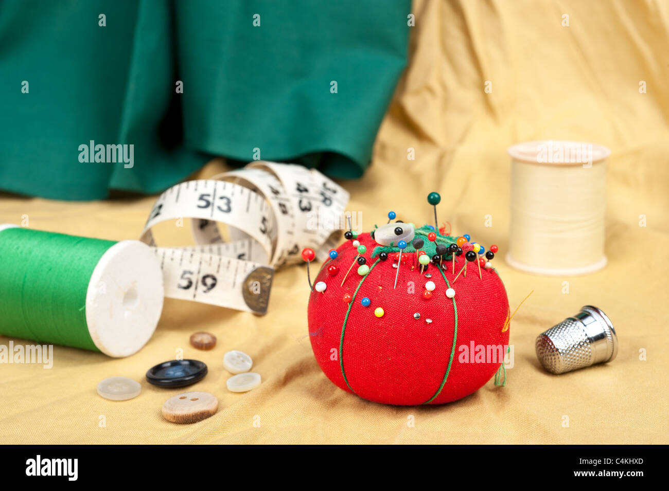 A sewing table with buttons, pin cushion, tape measure and thimble. Stock Photo