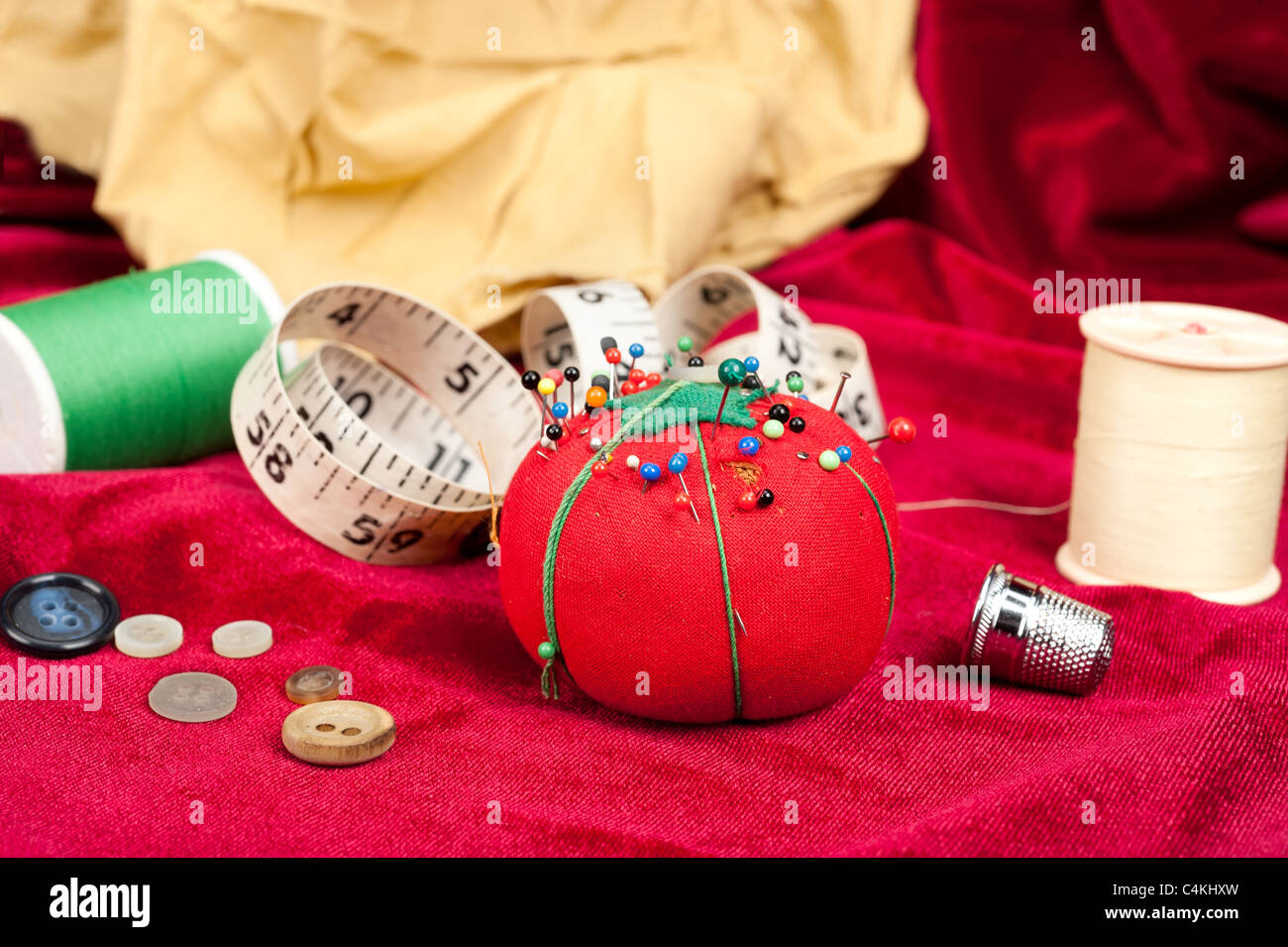 A sewing table with buttons, pin cushion, tape measure and thimble. Stock Photo