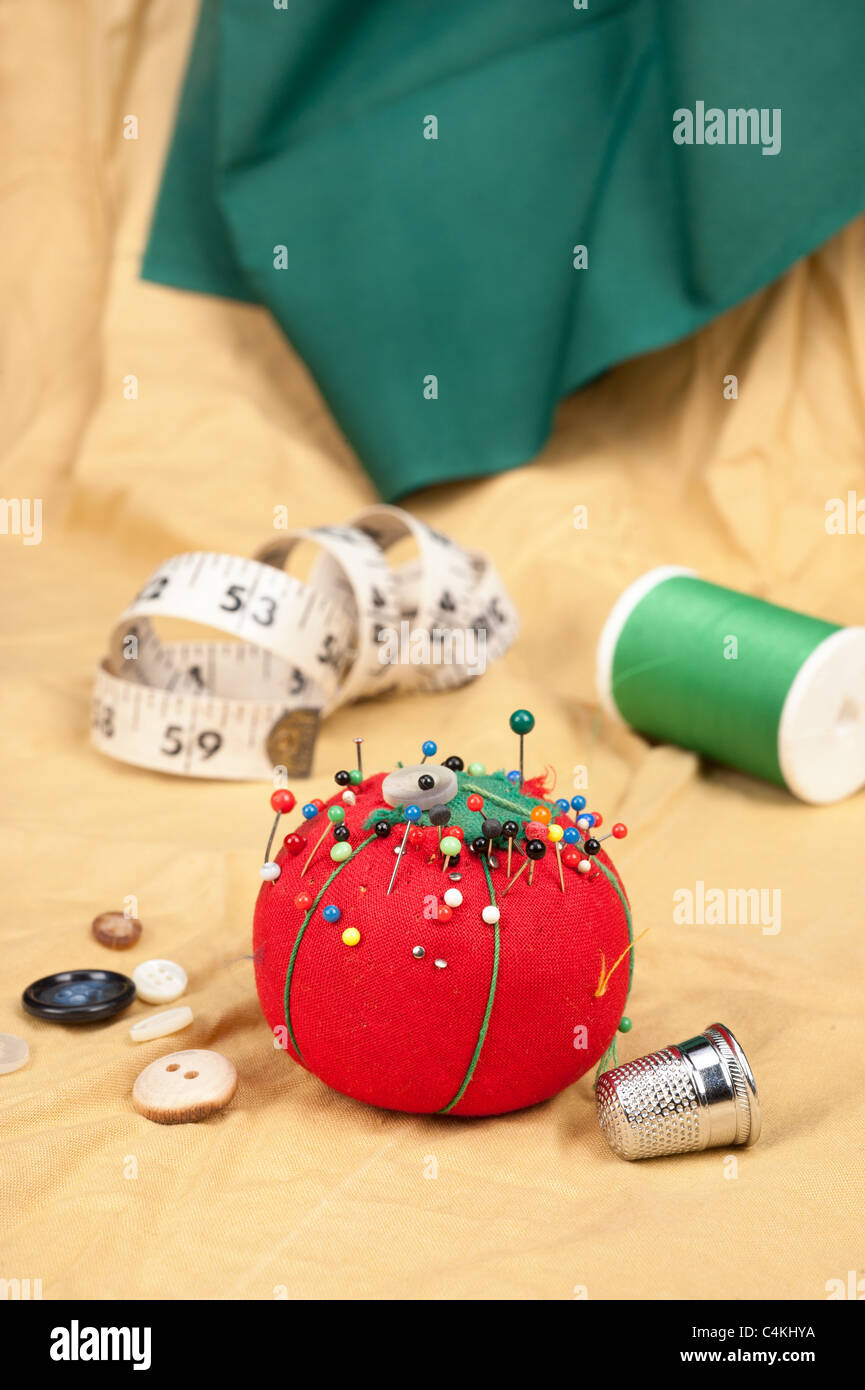 A sewing table with buttons, pin cushion, tape measure and thimble. Stock Photo