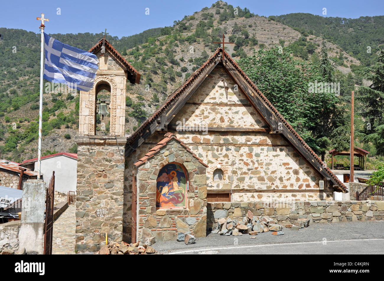 Church in village with flag in Troodos mountains in Cyprus Stock Photo