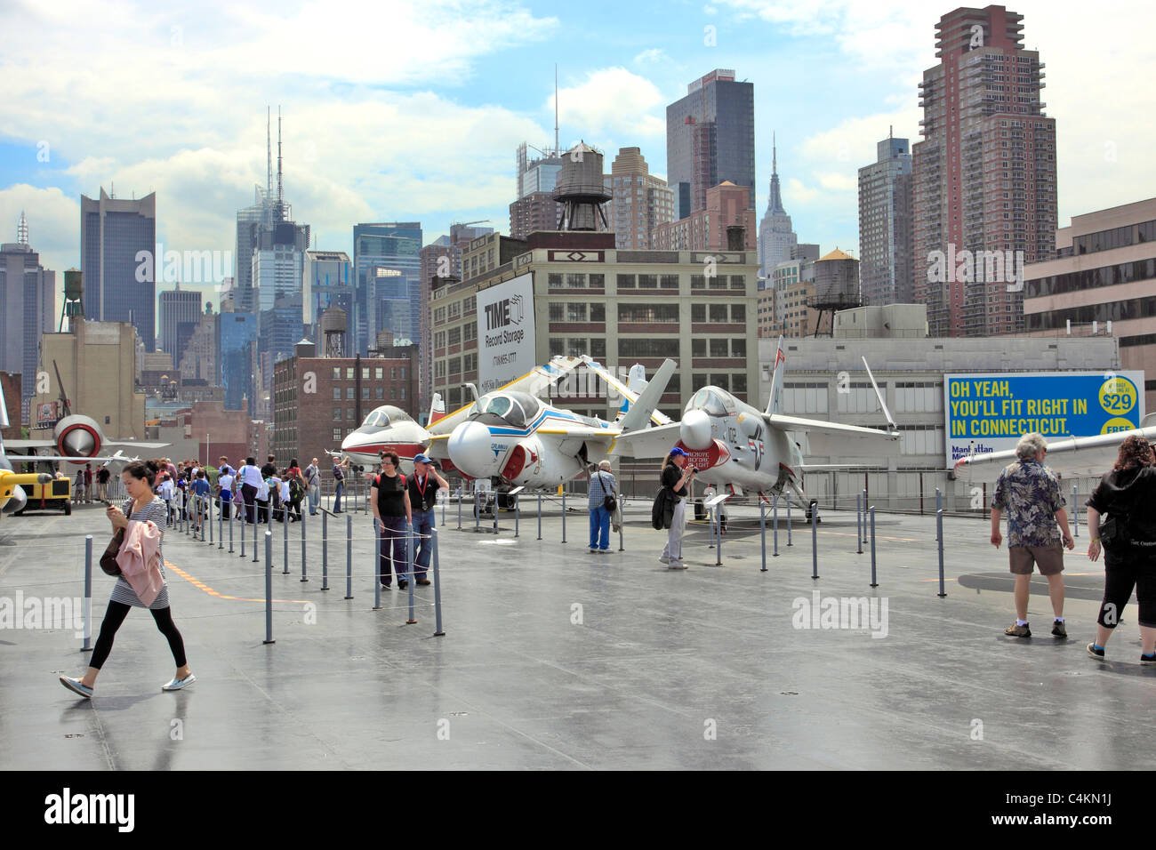 Tourists on flight deck of the USS Intrepid Aircraft Carrier Sea Air and Space Museum, Manhattan skyline in back, New York City Stock Photo