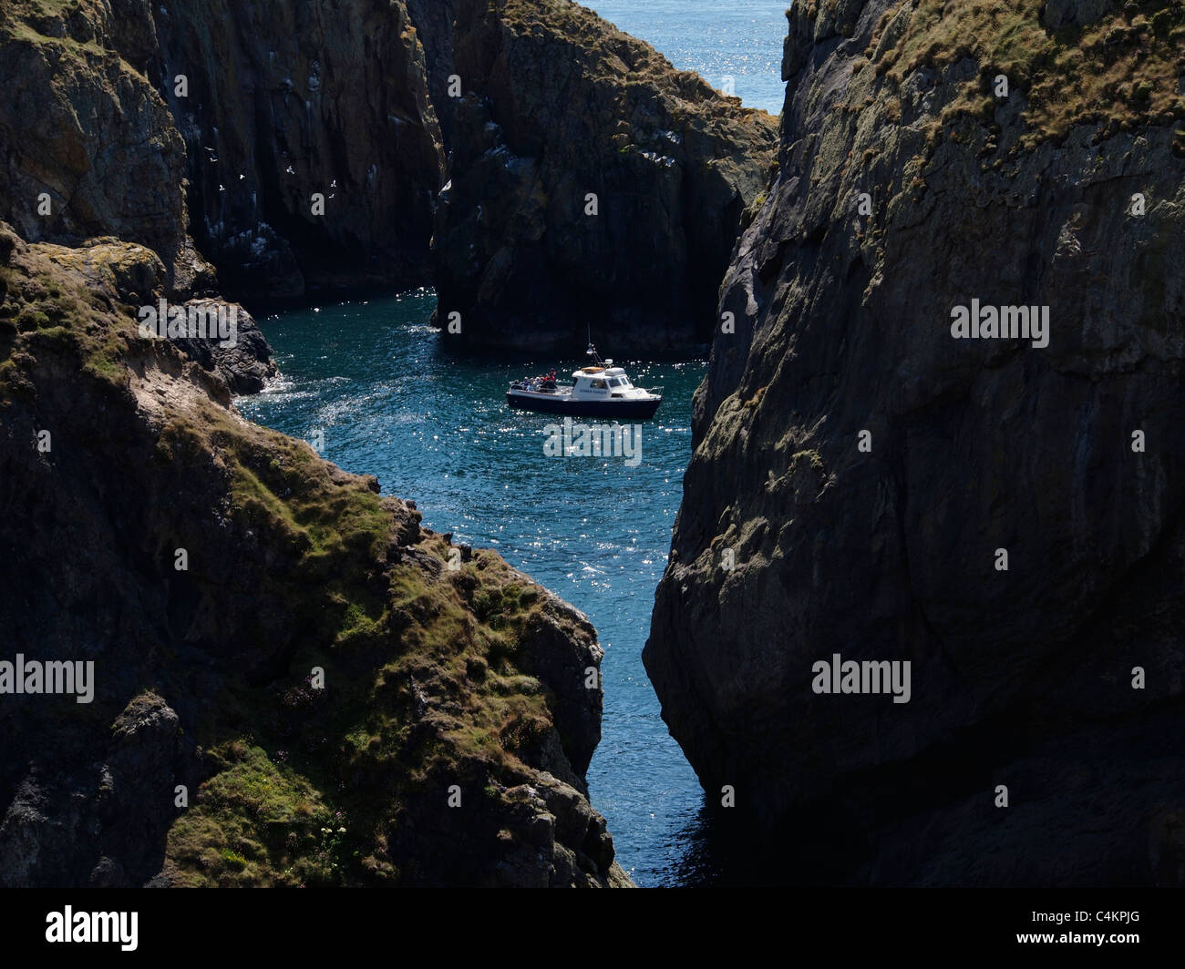Boat exploring inlet, Ramsey Island, Pembrokeshire, Wales Stock Photo