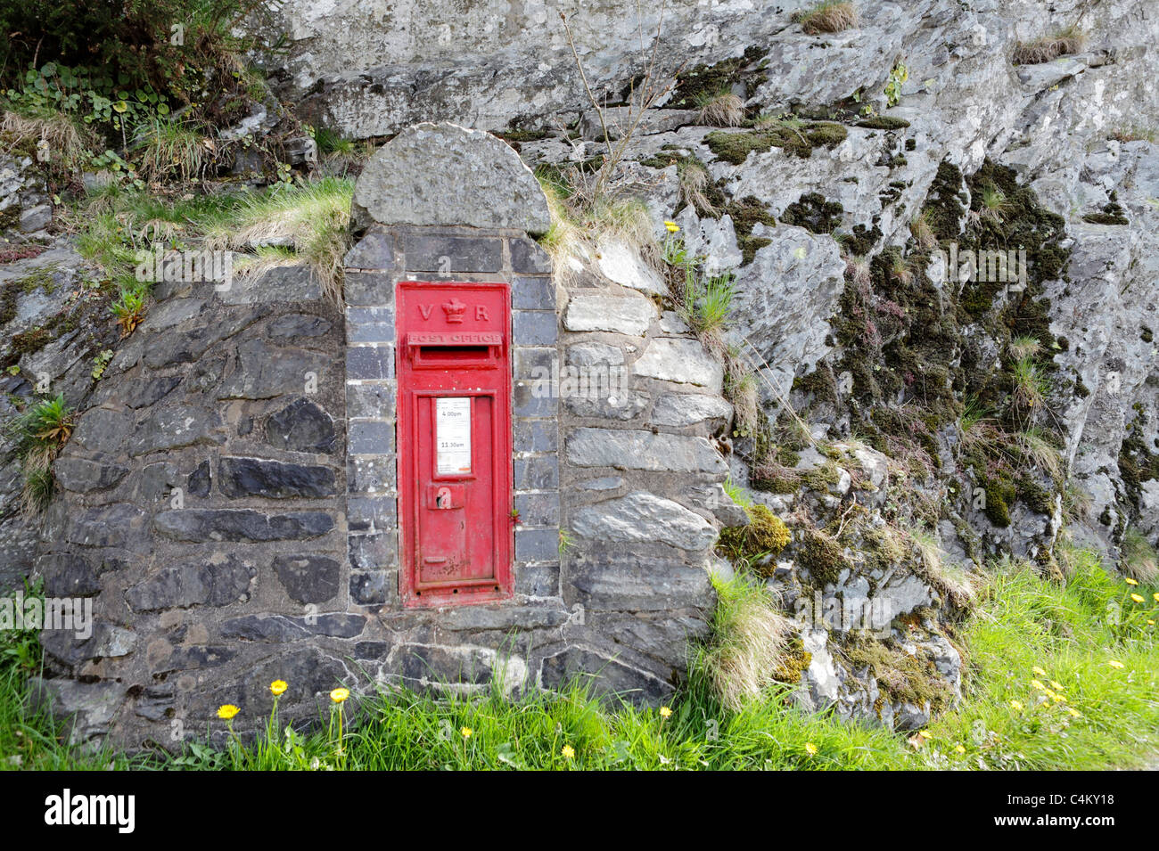 RED POST OFFICE LETTERBOX, set in stone at Lake Vyrnwy,the letters V R cast on it indicate it was of Victorian origin. Stock Photo