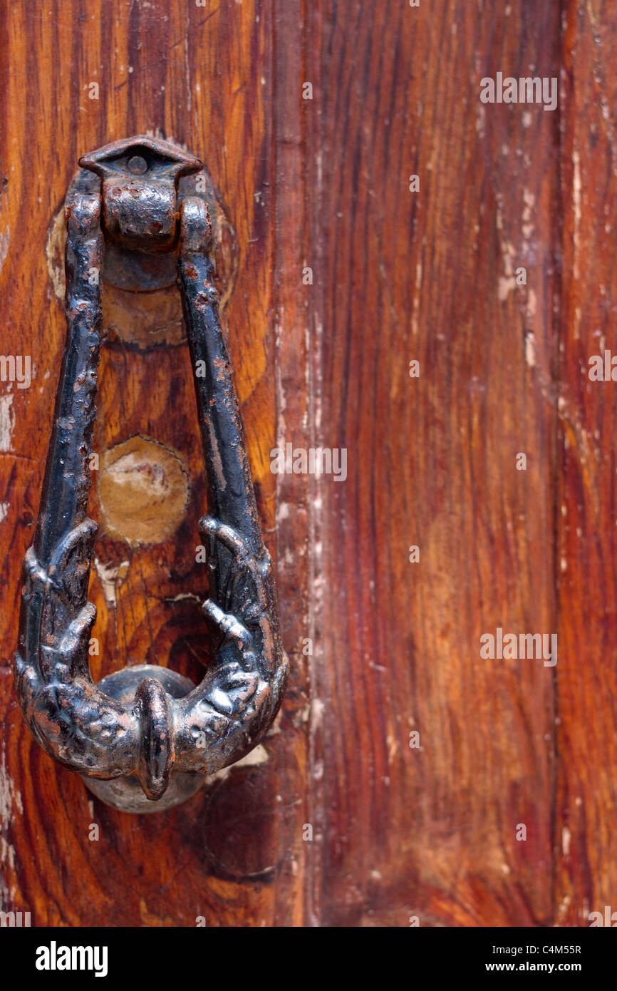 Old cast iron door knocker on varnished wooden door Stock Photo