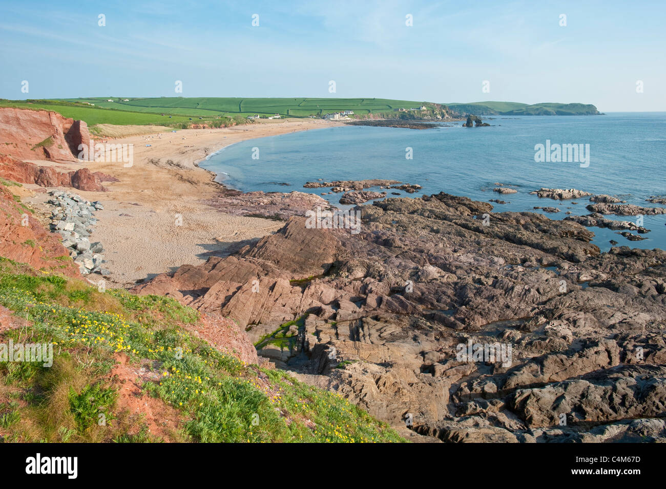 The rugged natural beauty of the Devon coastline opposite Thurlestone Golf Club and Thurlstone Rock in the distance upper right. Stock Photo
