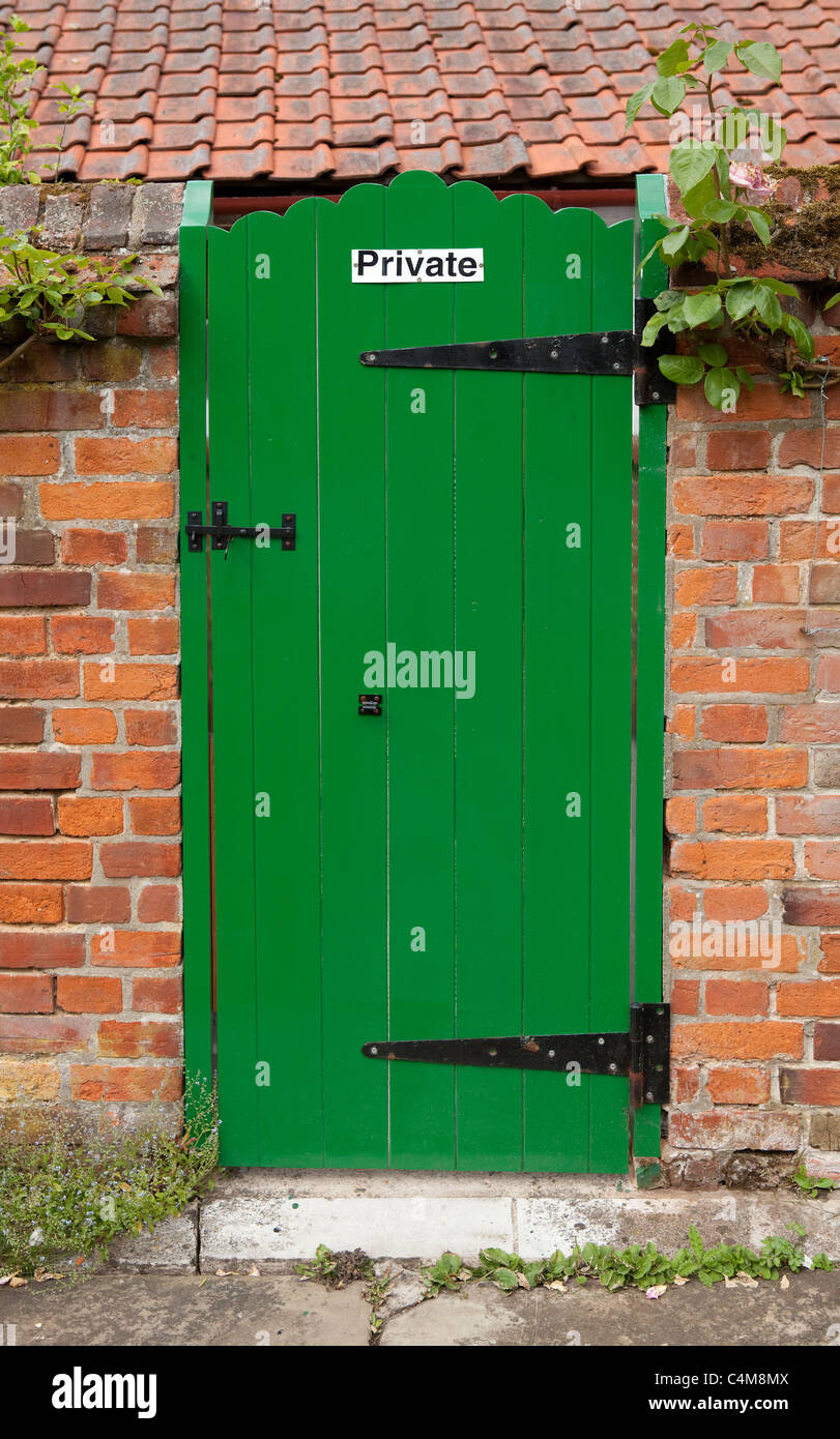 Green country garden gate door with 'Private' sign on it Stock Photo