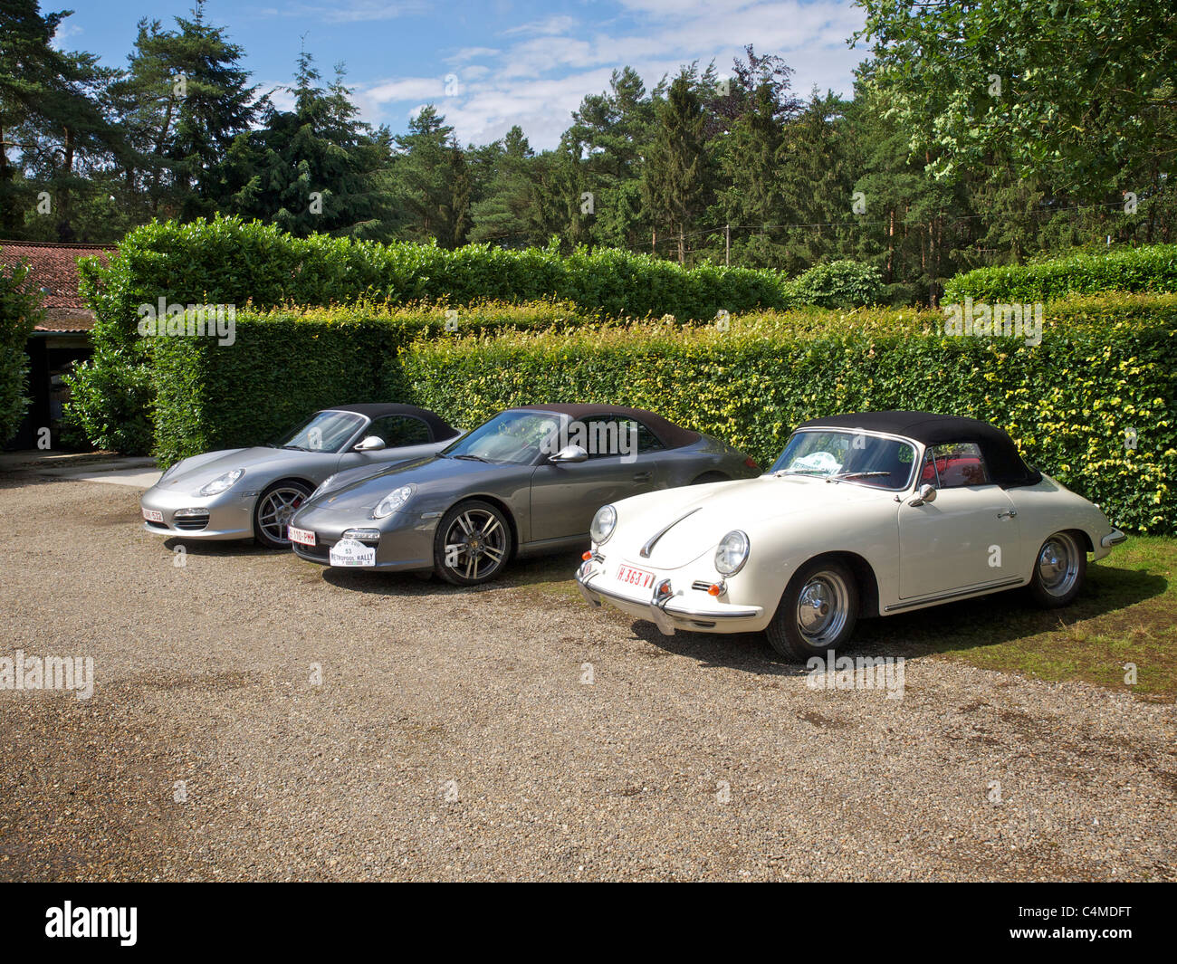three different convertible Porsches parked in a row. front to back a 356, a 911, and a Boxster. Stock Photo