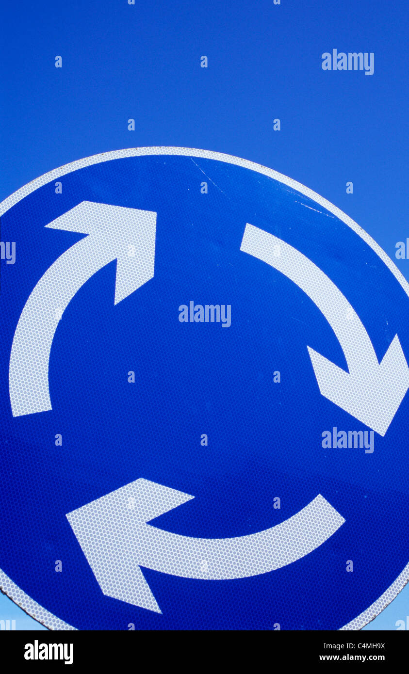 Circular blue and white traffic sign against blue sky showing three