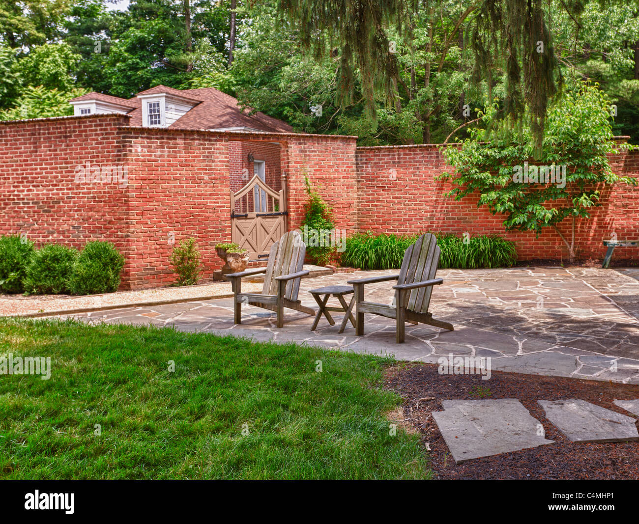 Wooden Cape Cod Style Chairs On Crazy Paving Patio In Front Of