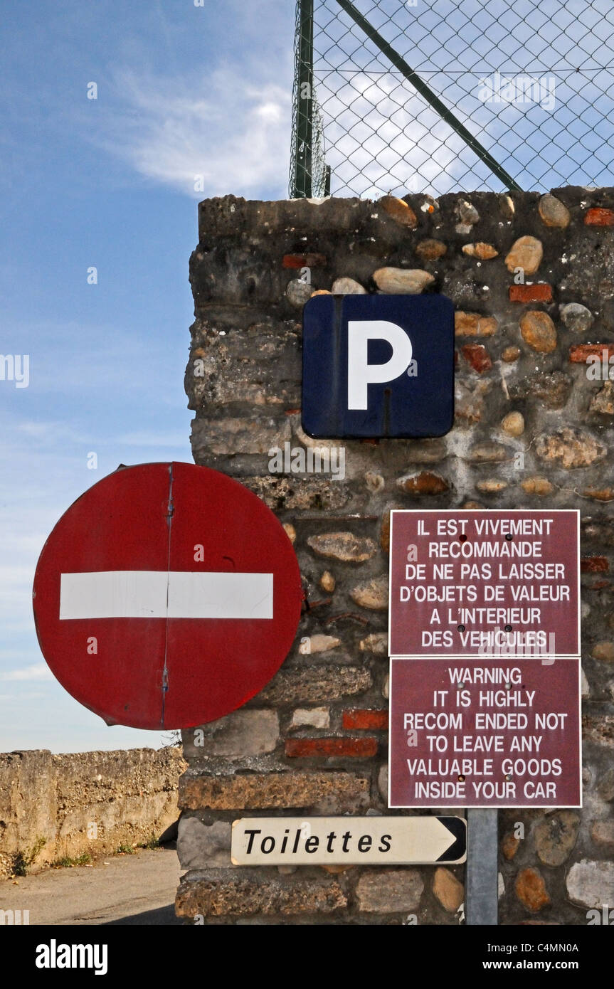 Signs for NO ENTRY TOILETTES PARKING and bilingual WARNING against thieves in Perouges Burgundy France Stock Photo