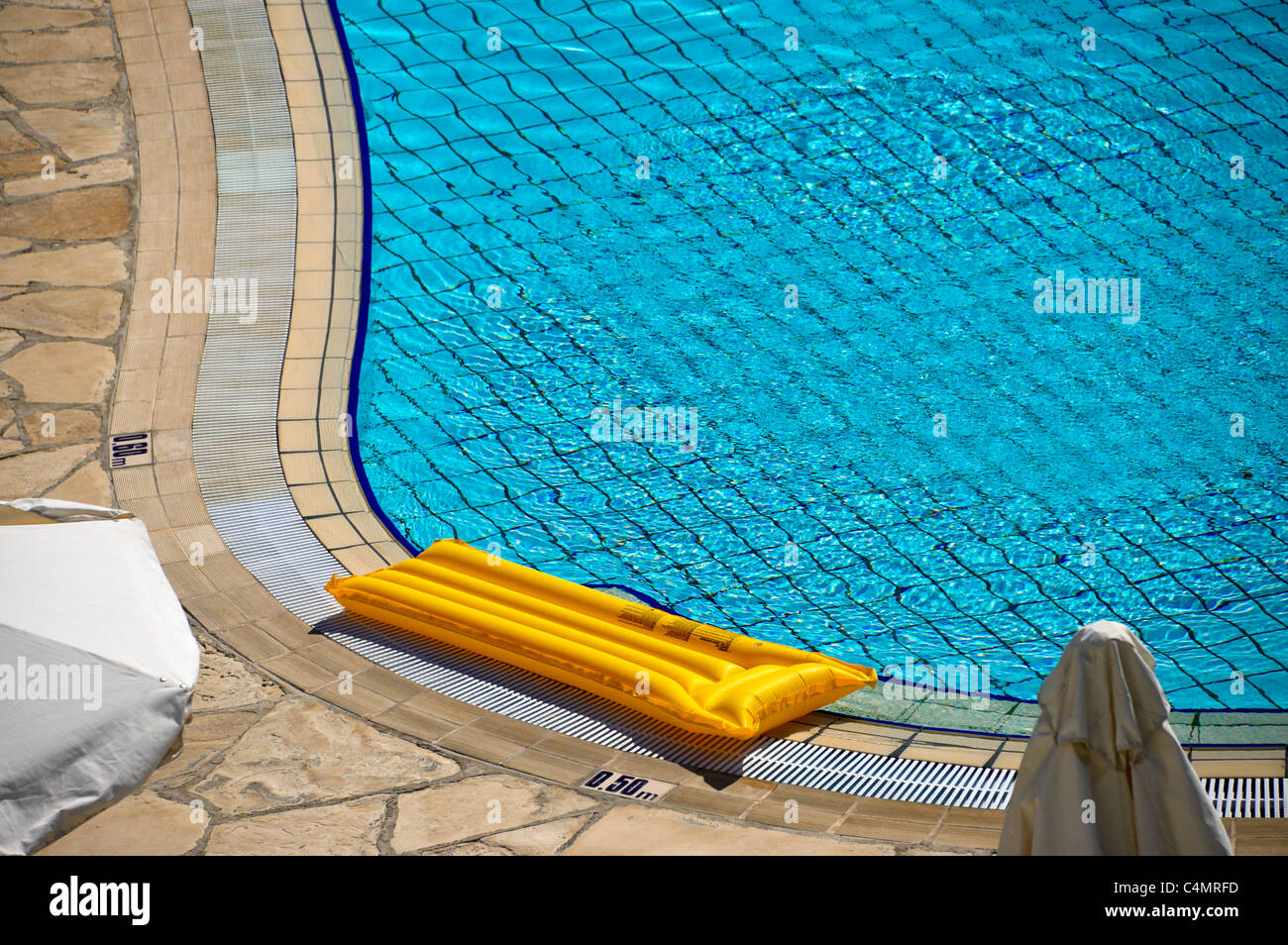 Hotel swimming pool and inflatable lilo. Stock Photo