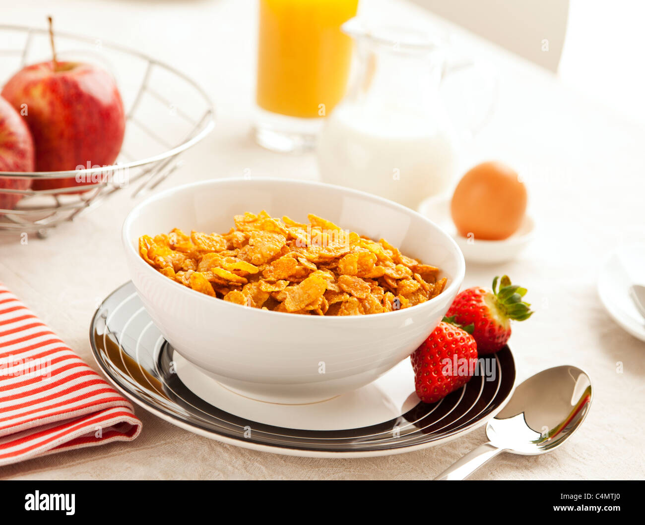 healthy breakfast with corn flakes, strawberries, apples, orange juice