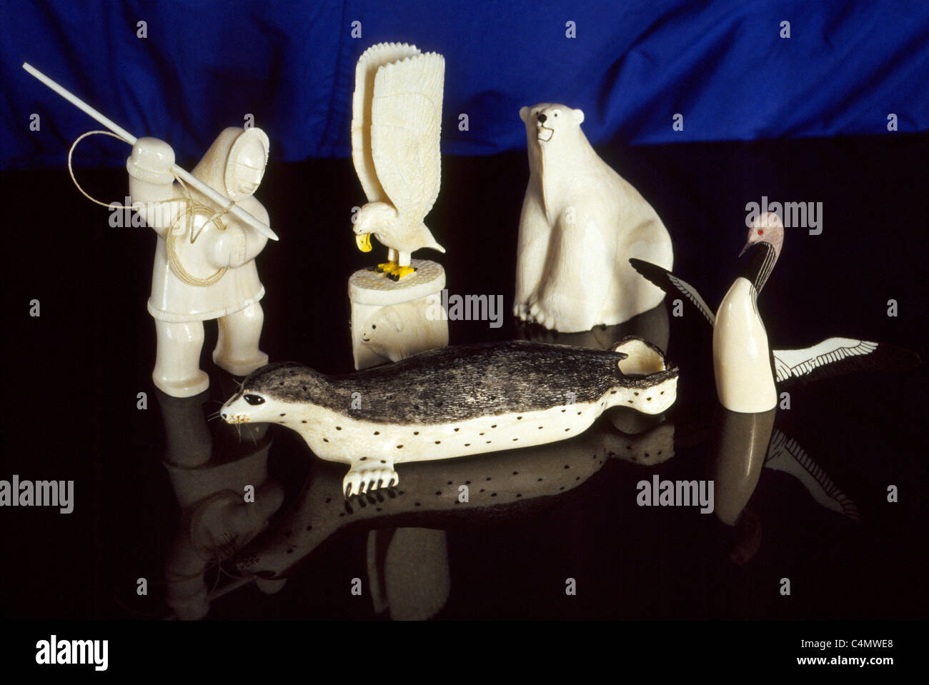 Ivory carvings like this hunter, eagle, polar bear, seal and seabird are treasured handicrafts sculpted by Native Alaskan artists in Alaska, USA. Stock Photo