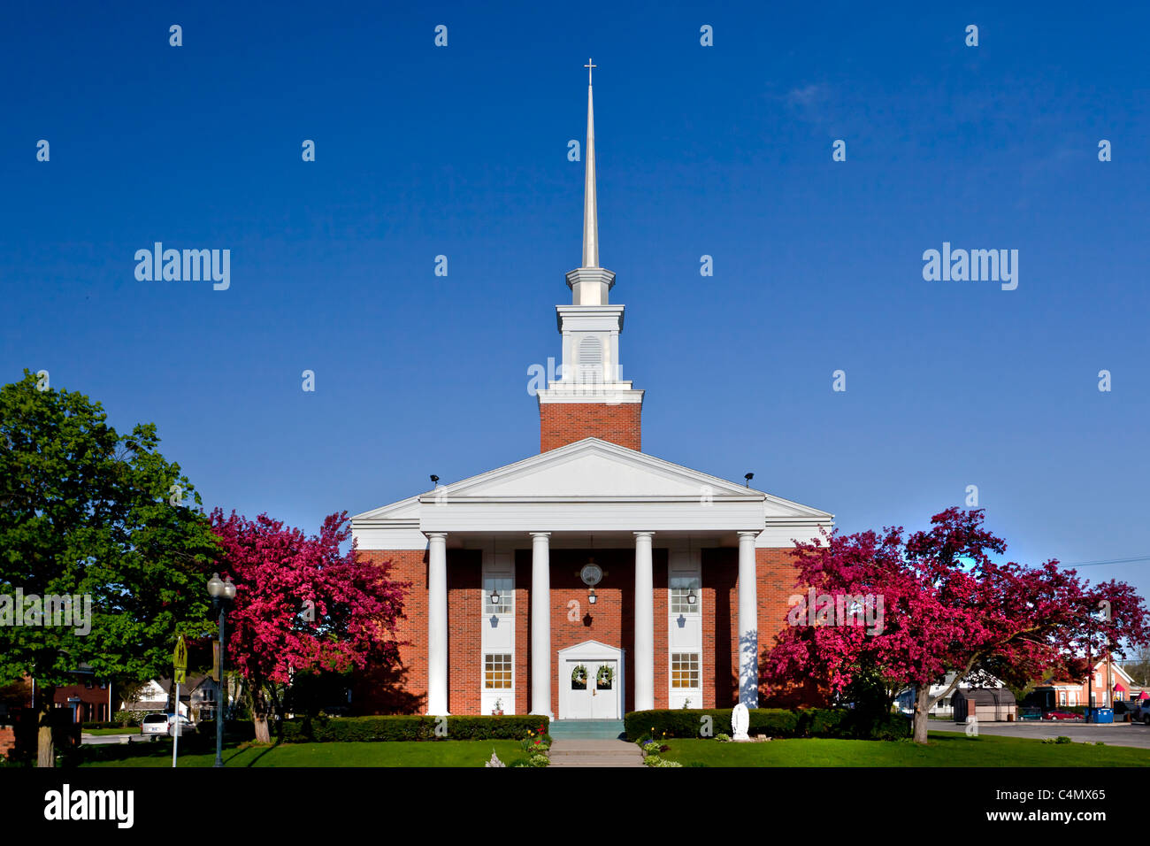 The St. John's Catholic Church with decorative cherry trees blooming in Goshen, Indiana, USA. Stock Photo