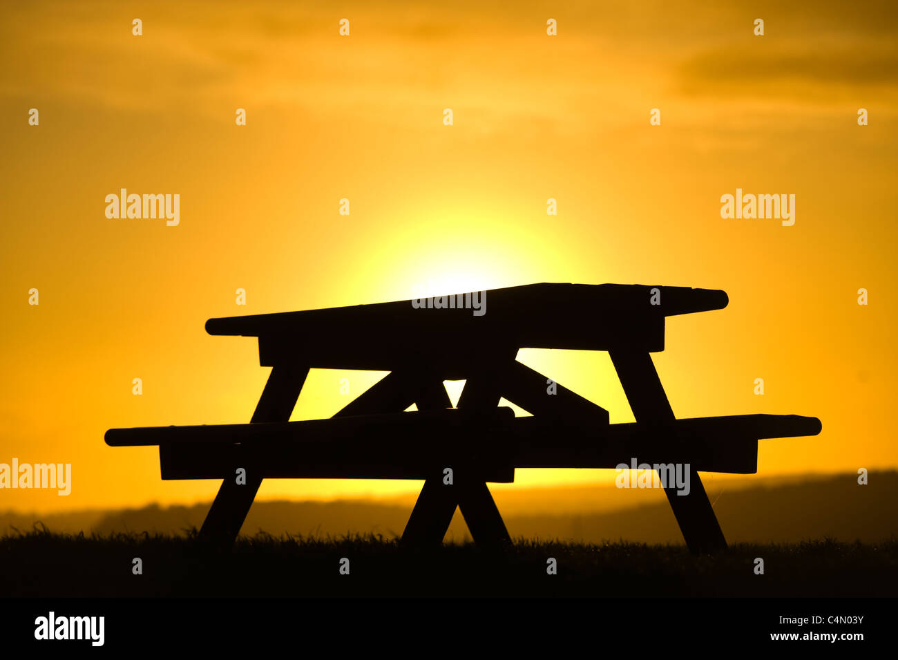 Picnic bench silhouetted at sunset Stock Photo