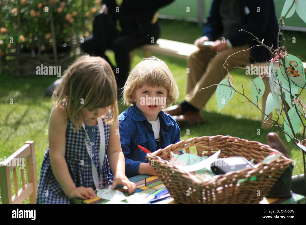 brother and sister creating leaves for a paper tree, Hay Literary Festival, 2011 Stock Photo
