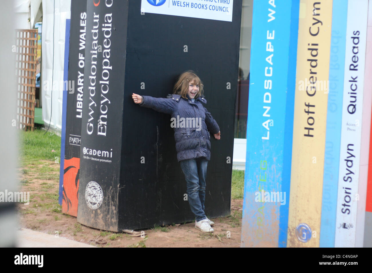 family tradition: sister poses for her parents (and me) holding up giant books at the hay literary festival Stock Photo