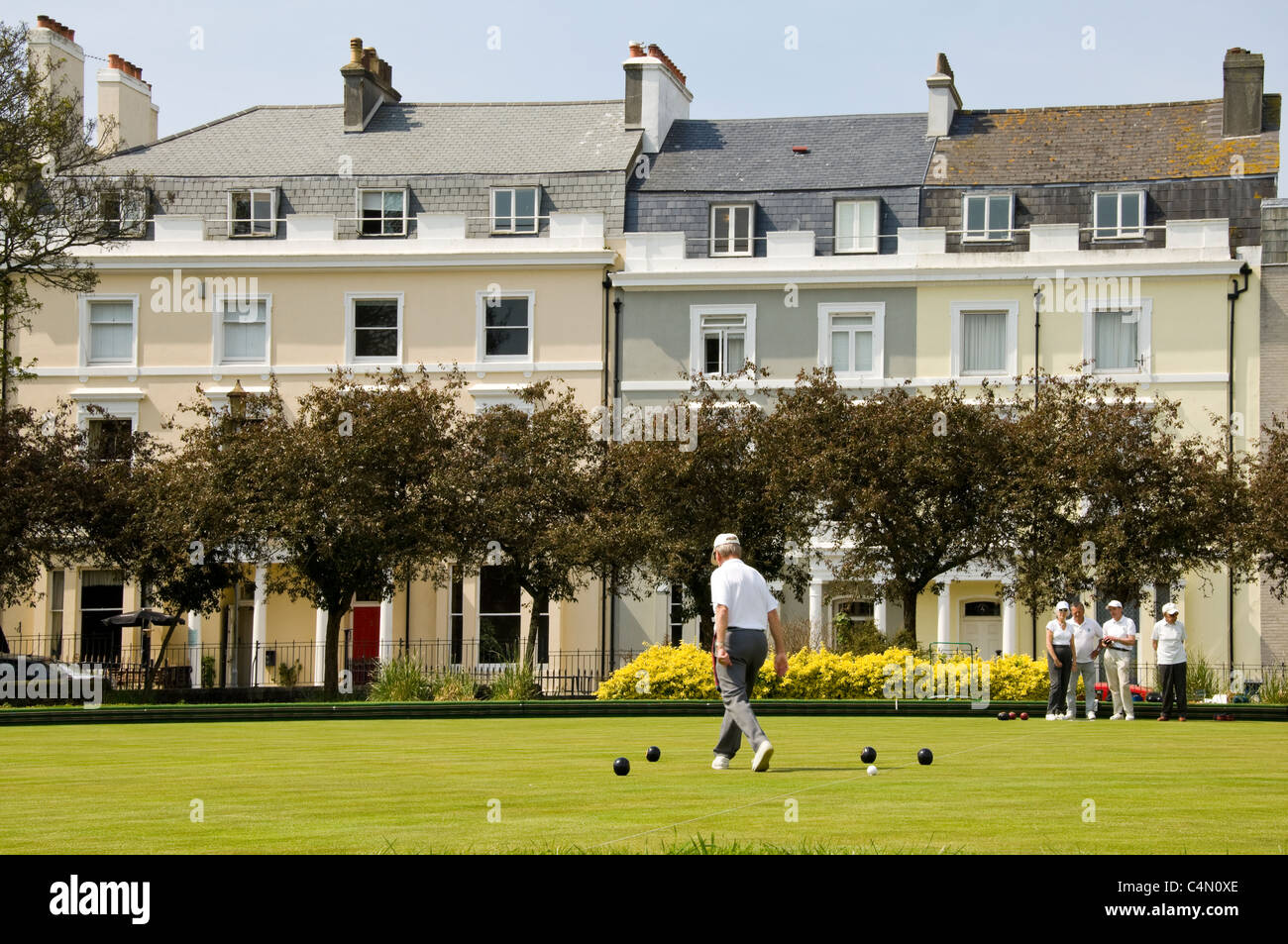 Horizontal view of people playing crown green bowls on a sunny day. Stock Photo