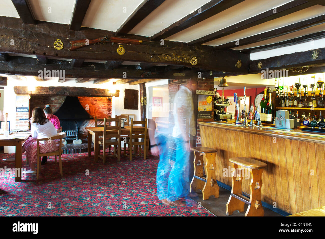 inside a typical Village Pub, with customers blurred by movement standing at the bar Stock Photo