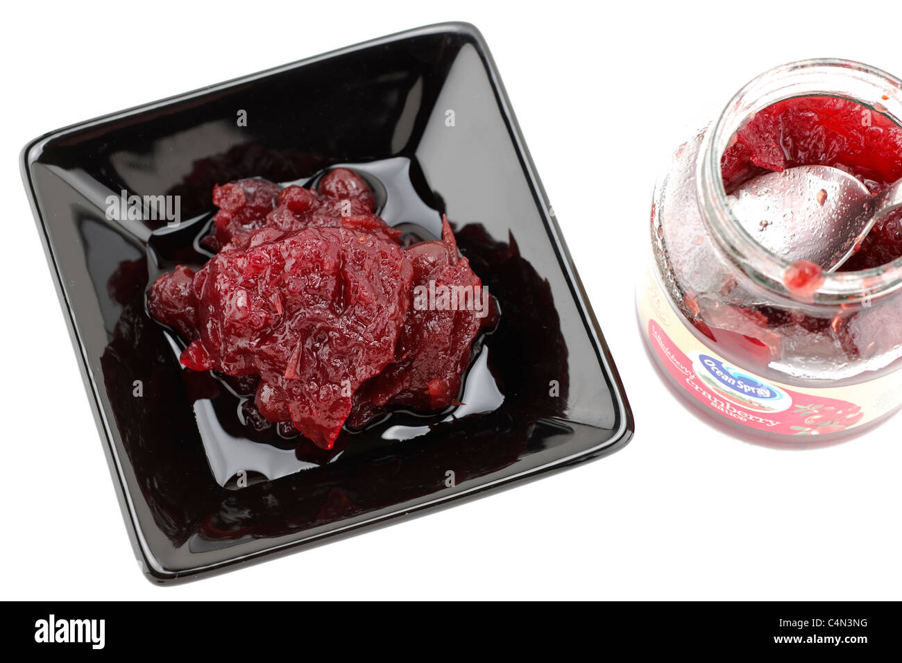 Cranberry sauce in a black serving dish jar and spoon Stock Photo