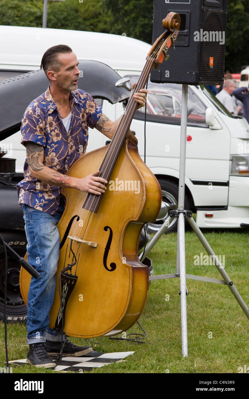 Teddy Boy Playing a Double Bass at an all American Car Show in England Stock Photo