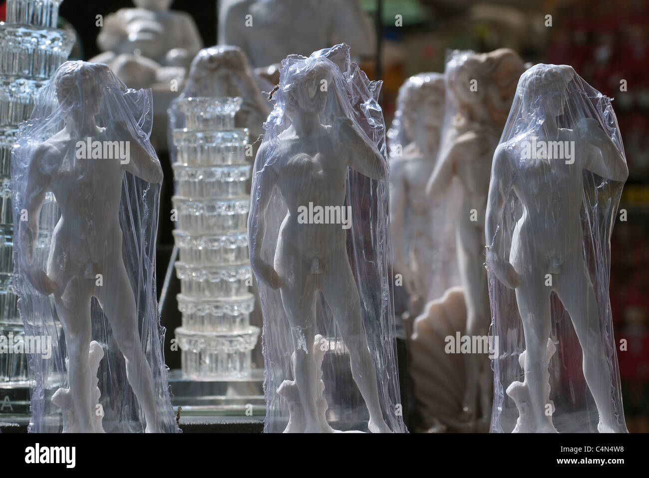 Small statues of Michelangelo's famous sculpture of David wrapped in clear plastic for sale to