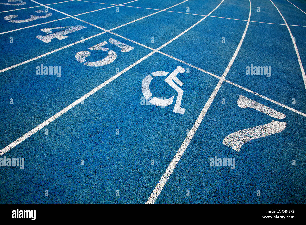 Handicap wheelchair icon superimposed on top of running track. Stock Photo