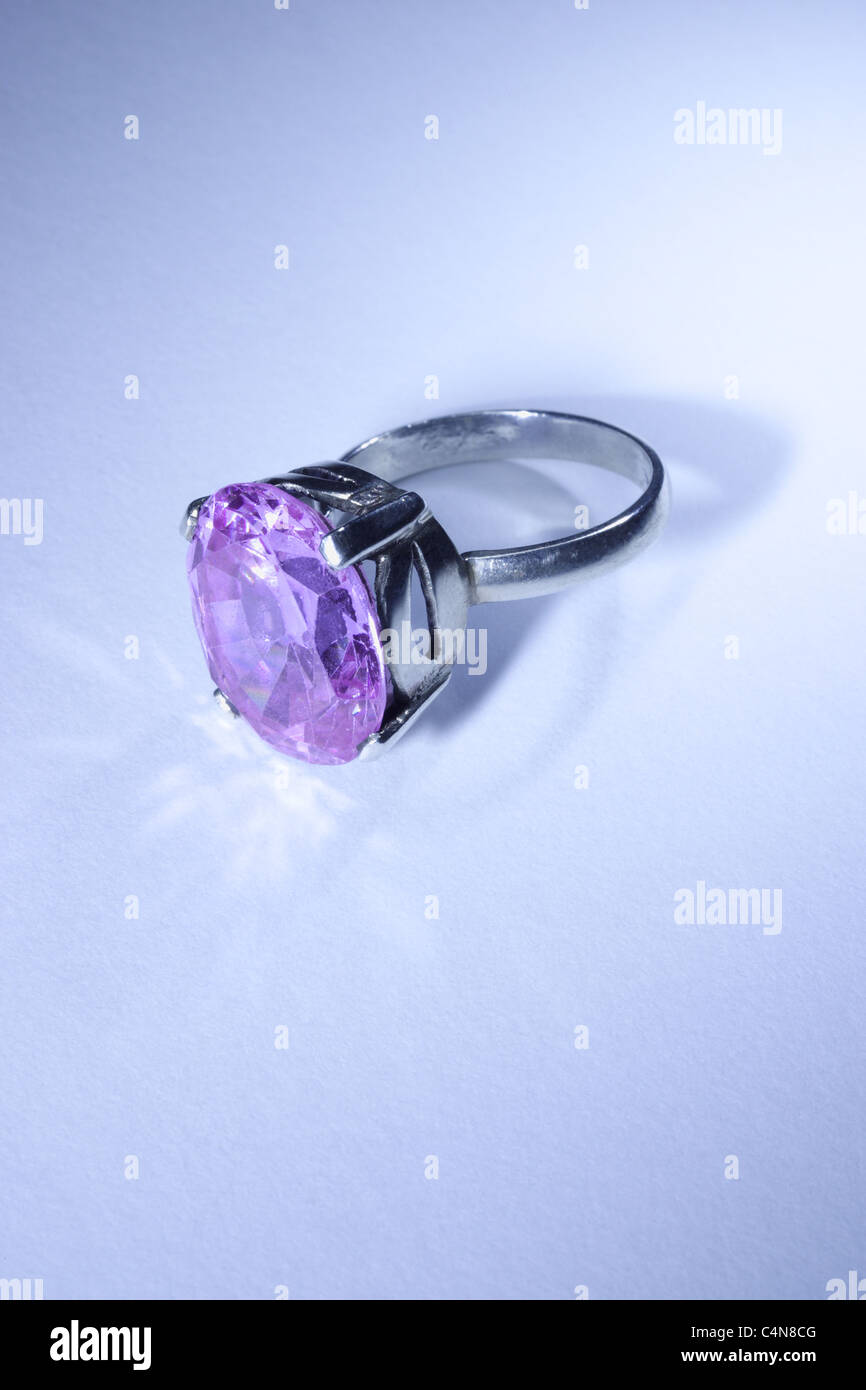 Jewelry ring with violet gemstone on blue background Stock Photo