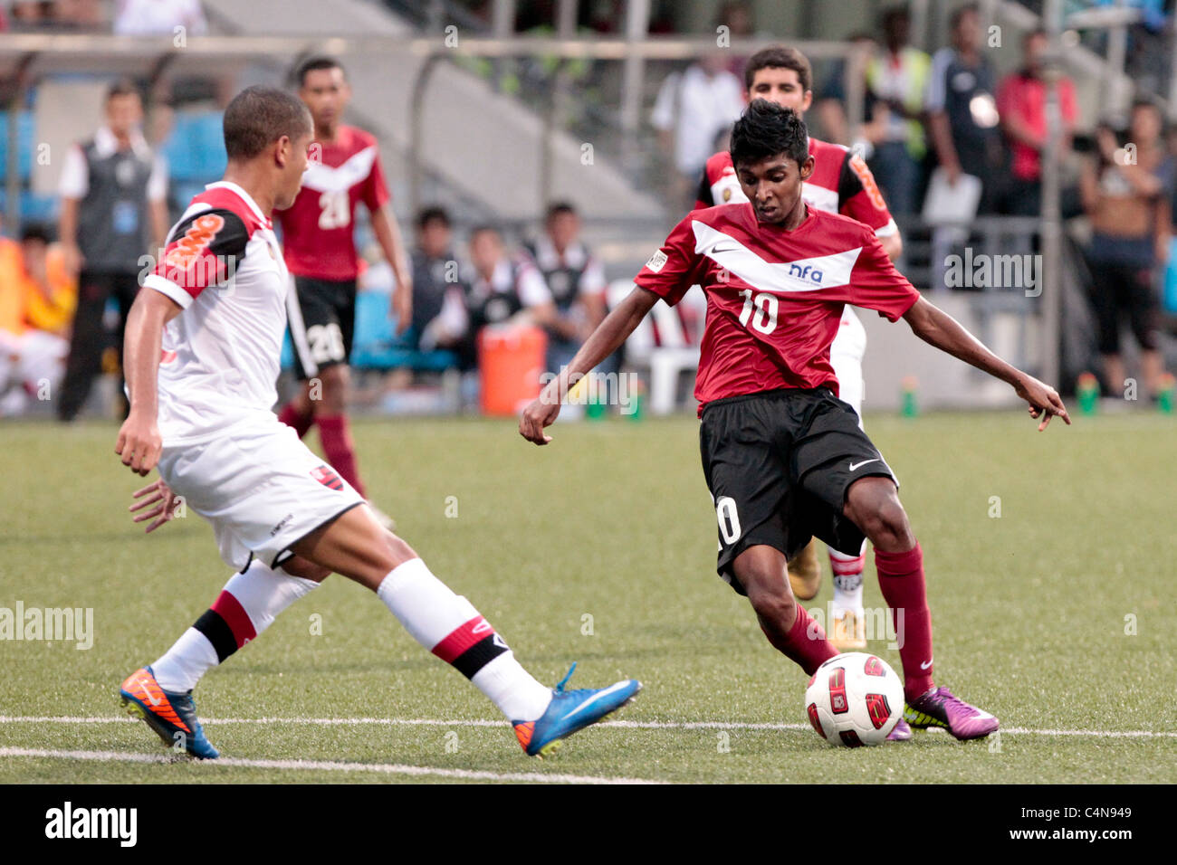 Hanafi Akbar of Singapore U16(red) makes a run at the Flamengo defence during the 23rd Canon Lion City Cup. Stock Photo