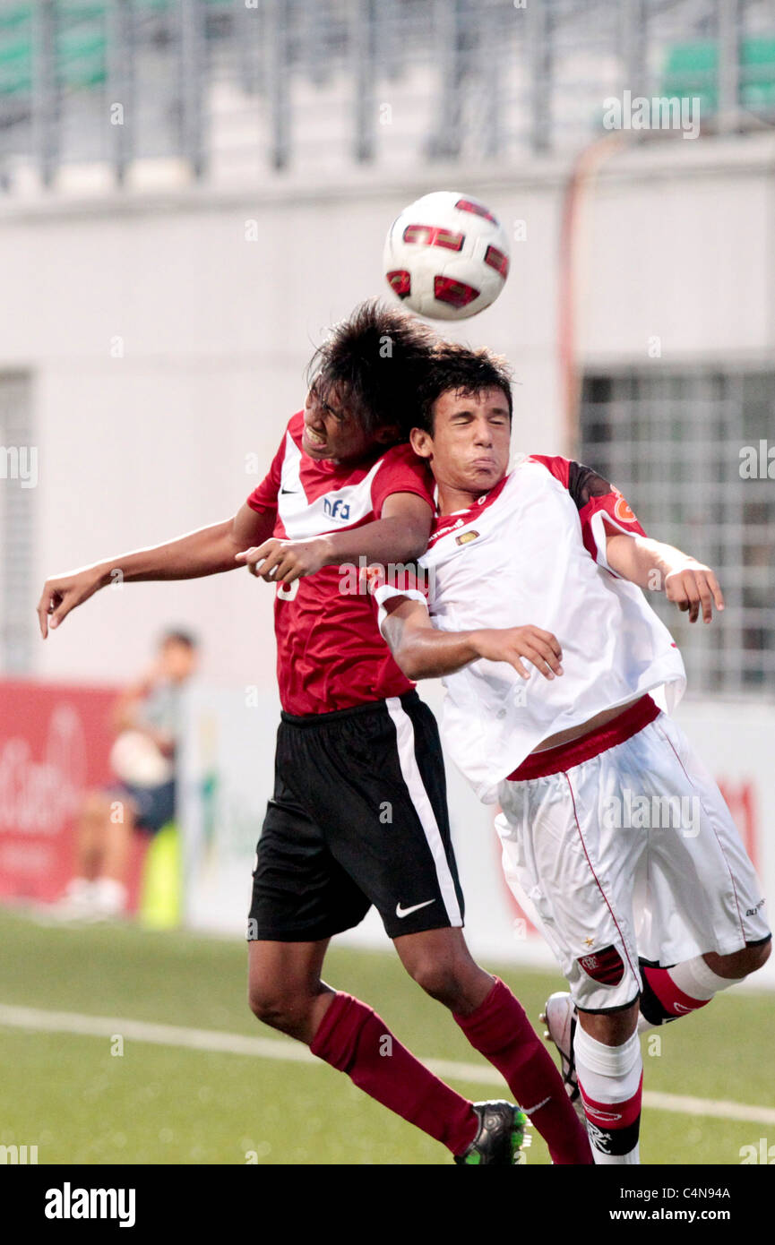 Ammirul Mazlan of Singapore U16(red) and Caio Thimoteo battle for the aerial ball during the 23rd Canon Lion City Cup. Stock Photo