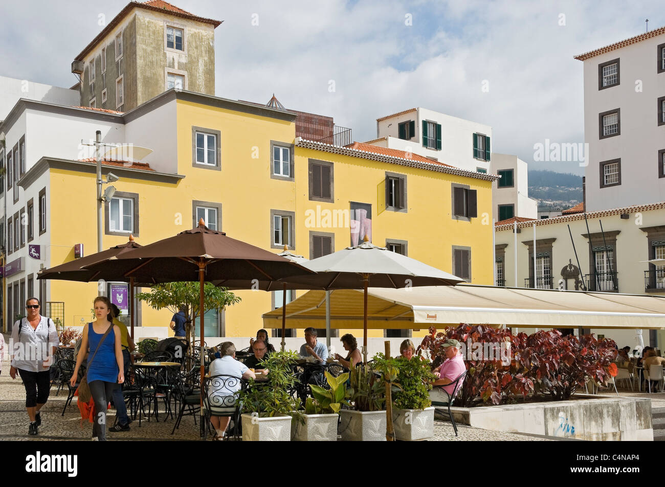 People tourists visitors sitting sat at outdoor cafe with the Museum of Sugar in the background Funchal Madeira Portugal EU Europe Stock Photo