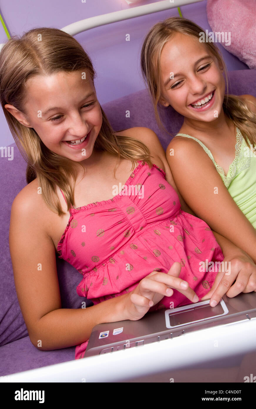 two girls playing on laptop, highlighting the urban lifestyle in Brazil and the USA, where roughly 80% of the population in both countries resides in cities