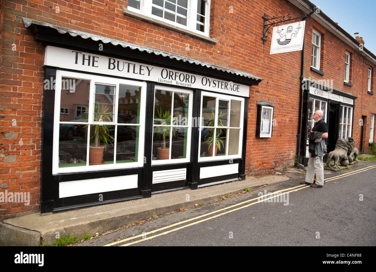 A man looking at the menu outside The Butley Orford Oysterage, Orford village Suffolk UK Stock Photo